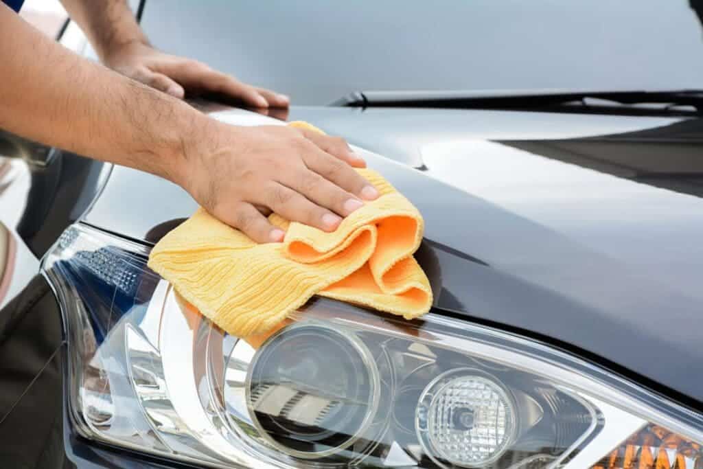 A person wiping off the car window with a car wiper