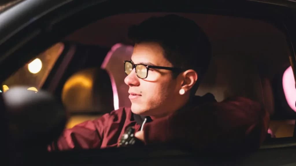 A person driving in the night wearing yellow tinted night glasses