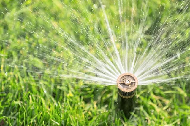 A water sprinkler sprinkling water in grass