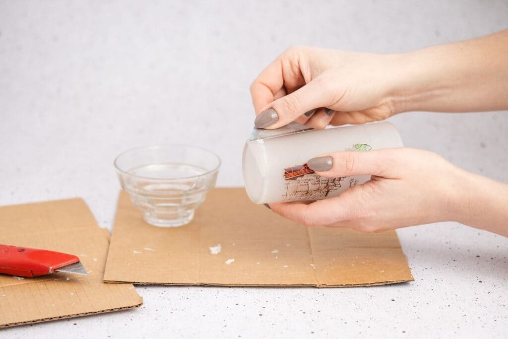 A hand picking broken glass pieces