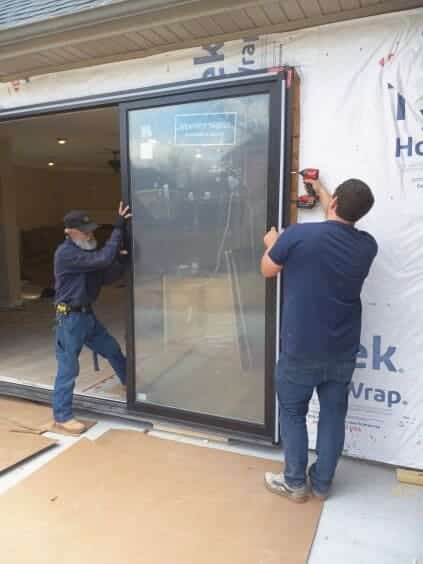 Two people fitting the sliding glass door