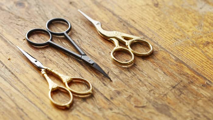 three pairs of scissors on a wooden board