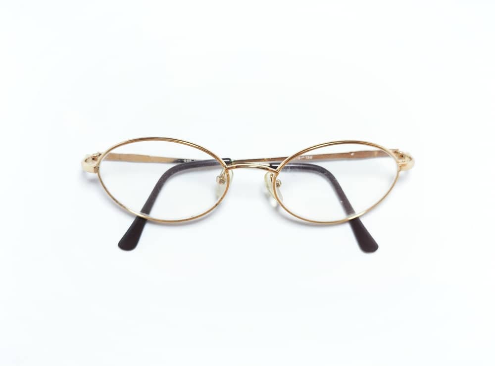 Gold Oval Glasses With Black Temple Tips And A White