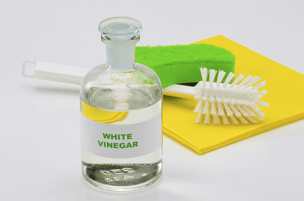 a jar of ywhite vinegar with brush sponed and soft cloth