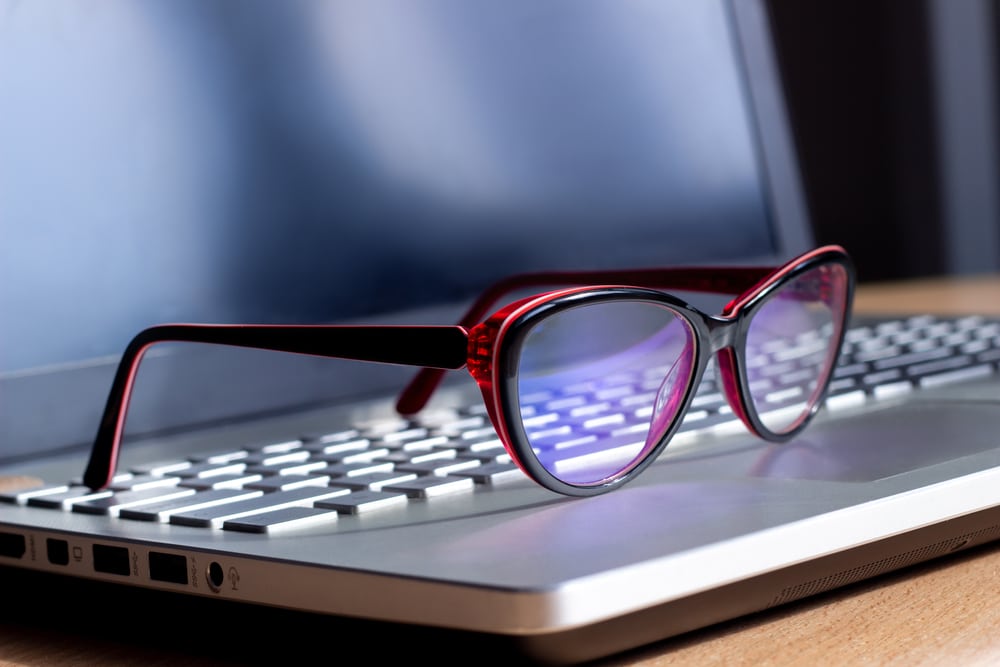 Red And Black glasses placed on the laptop 