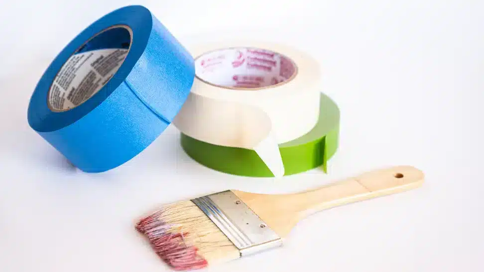 three types of painter tapes and a paint brush