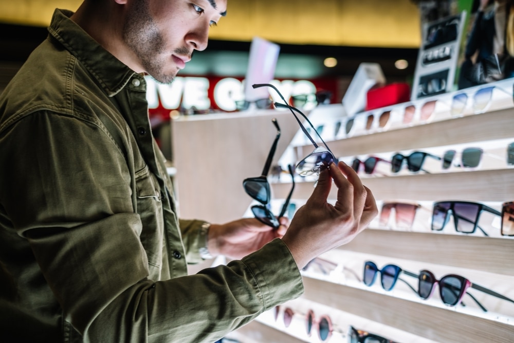 A view of a guy holding sunglasses at a store