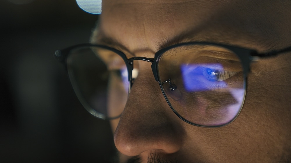 A close view of a person wearing blue light glasses A close view of a person wearing blue light glasses