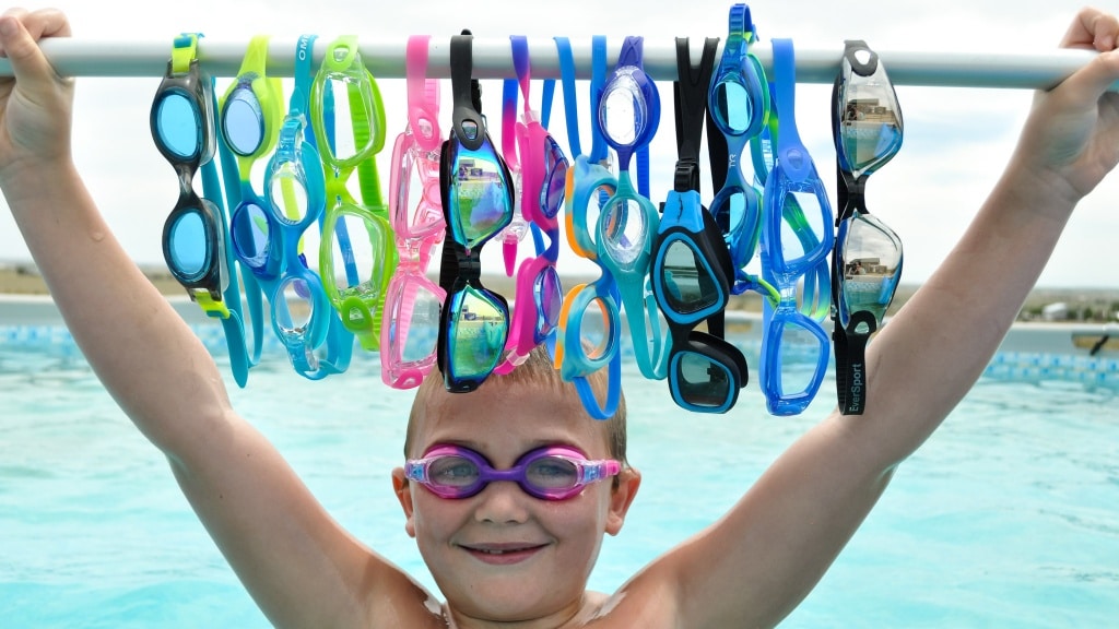 A view of a boy wearing swimming glasses holding a bar of glasses A view of a boy wearing swimming glasses holding a bar of glasses