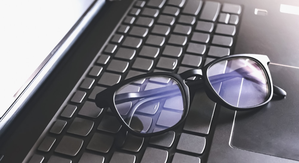 A view of glasses placed on laptop keyboard A view of glasses placed on laptop keyboard